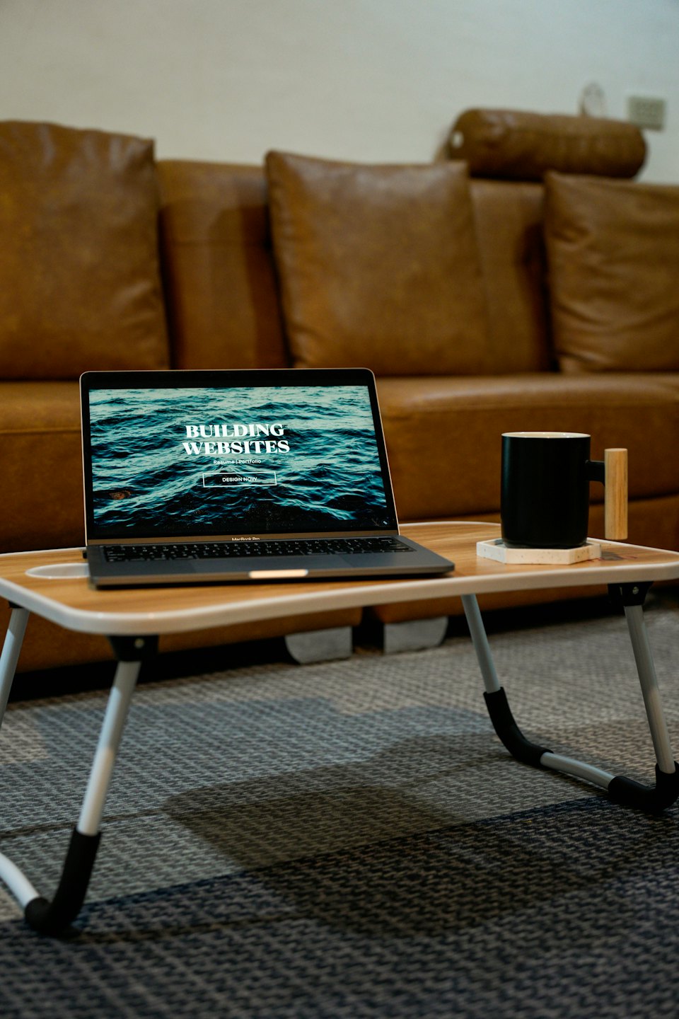 Laptop showing website development on a portable desk.